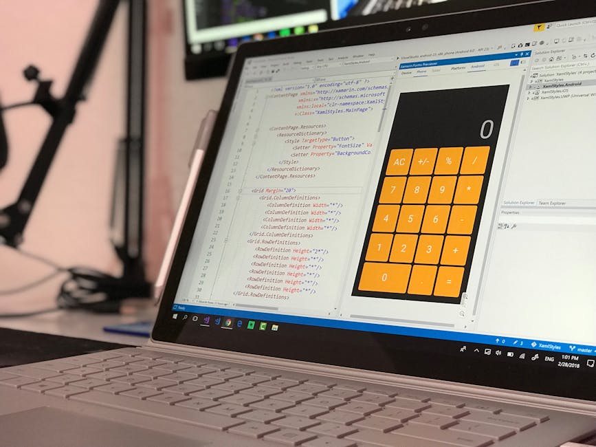 A close-up view of a laptop computer displaying a computer screen with lines of coding in various colours, including red, blue, and black, on the left side. The right side features a large, orange dig